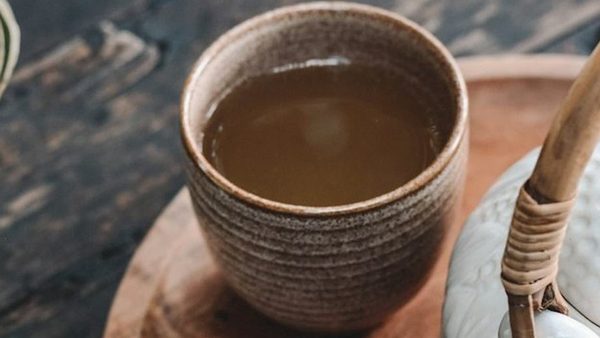 A cup of warm tea on a wooden tray