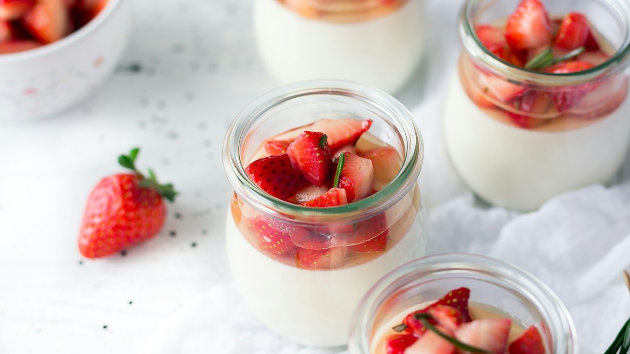 Small cups of yogurt topped with strawberries